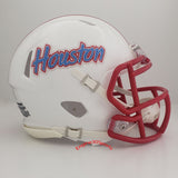 A white Houston Cougars football helmet with a red faceguard and red stripe on the crown, featuring the Houston wordmark in red and blue on the side. A tribute to the Houston Oilers.